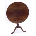 A mahogany tilt top occasional table, with a circular top on a turned column and tripod base,