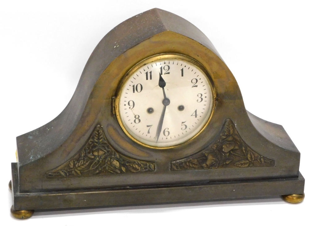 An unusual early 20thC patinated brass mantel clock, of arched form with two panels, each