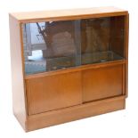 A 1960s oak bookcase, with two sliding glass doors and two sliding doors on a plinth, 91cm wide.