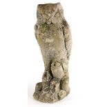 A composition stone model of an owl, positioned perched on a rock, 37cm high.