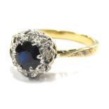 A sapphire and diamond dress ring, set in a floral cluster with circular cut dark sapphire,