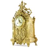 A late 19th/early 20thC French cast brass cased mantel clock, decorated with female mask, rococo