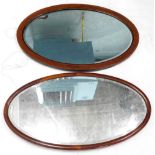 Two Edwardian mahogany oval wall mirrors, each with a bevel plate, one with boxwood strung border,