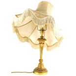 A continental gilt metal table lamp, cast with leaves on a tapering base, with decorative shade with
