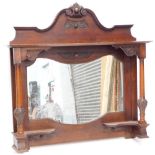 A late 19th/early 20thC walnut overmantel mirror, the shaped top carved with a central flower