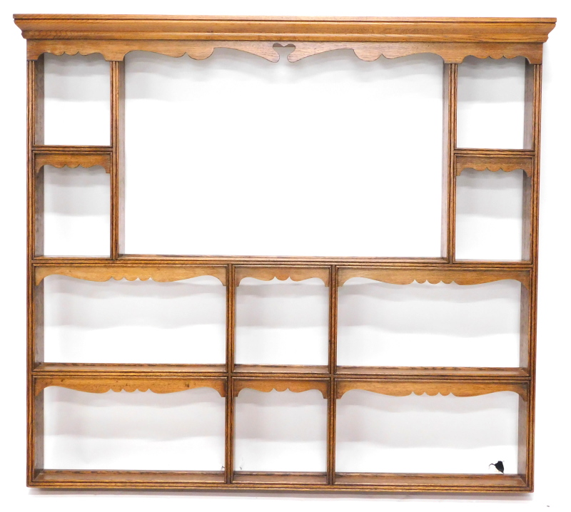 An oak plate or Delft rack, the top with a moulded cornice, above a shaped frieze above various