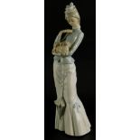 A Lladro porcelain figure of a tall lady, holding a Pekingese dog whilst holding a parasol, 38cm