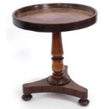 A mahogany occasional table, with a circular dished top, on a turned column and triform base, with