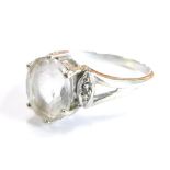 A 9ct gold dress ring, with large central white topaz, in claw setting with tiny white stone set