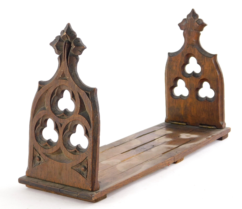 A Victorian pitch pine Gothic adjustable book holder, 43cm wide enclosed.