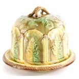 A Victorian majolica cheese dome and cover, decorated with leaves within arched compartments, the