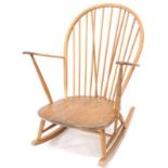 An Ercol rocking chair, the shaped back with spindle turned supports, curved arms and solid elm seat