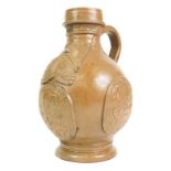 A stoneware Bellarmine jug, decorated with a bearded mask and with three continental crests,