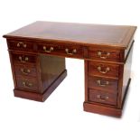 A late 19th/ early 20thC mahogany pedestal desk, the rectangular top with a maroon leather insert,