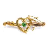 A 9ct gold bar brooch, the scroll design bar with heart shaped central emblem, set with green stone,