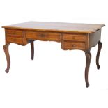 A French oak bureau plat or writing table, the rectangular top with a shaped moulded edge above five