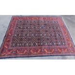 An Indian Mahal carpet, with an all over design of flower heads, medallions, etc., on a navy ground,