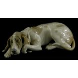 A Lladro porcelain figure of a recumbent hound, 25cm long.