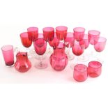 A collection of cranberry tinted wine glasses, a beaker, two small custard cups and two jugs.