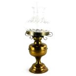 A 20thC brass oil lamp, with clear shade, on domed foot, 52cm high.