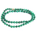 A malachite graduated beaded necklace, with a brass screw in clasp, 64cm long overall.