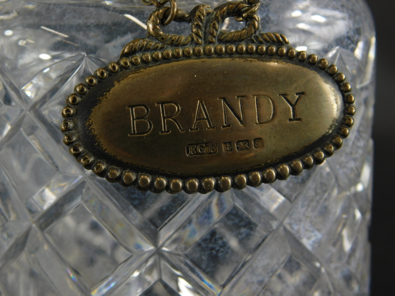A pair of cut glass decanters and stoppers, and one silver decanter label for brandy, with beaded - Image 2 of 2