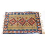 An Eastern Turkish Kilim rug, with a typical geometric design in brown, red, blue and yellow,
