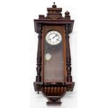 A late 19thC Vienna type wall clock, in a walnut case with a white enamel dial flanked by part