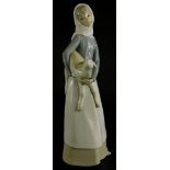 A Lladro porcelain figure of a lady holding a lamb, 27cm high.
