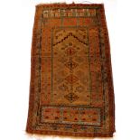 A Persian type rug, with a design of lozenges, in orange on a faun ground, 86cm x 145cm.