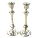 A pair of Elizabeth II silver candlesticks, each with reeded decoration, with a waisted column and