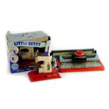 A Mettoy tin plate child's typewriter, a Little Betty child's sewing machine and another. (boxed)