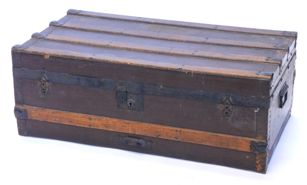 A canvas and wooden bound trunk, with metal brackets and side handles, 79cm wide.