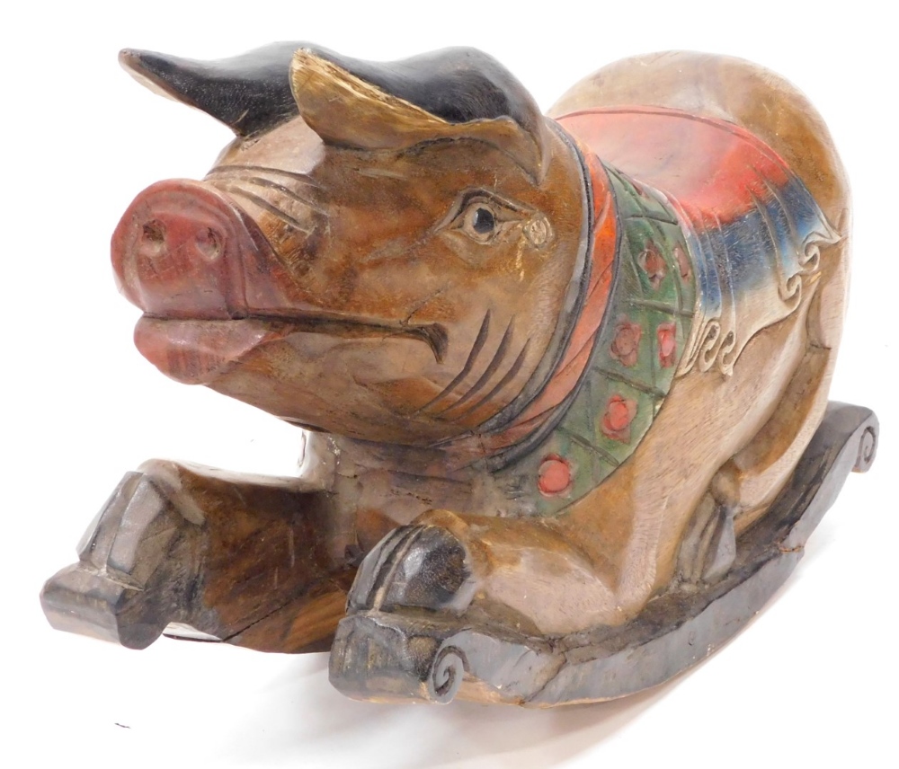 An Eastern carved hardwood rocking pig, with polychrome painted saddle etc., on scrolled carved