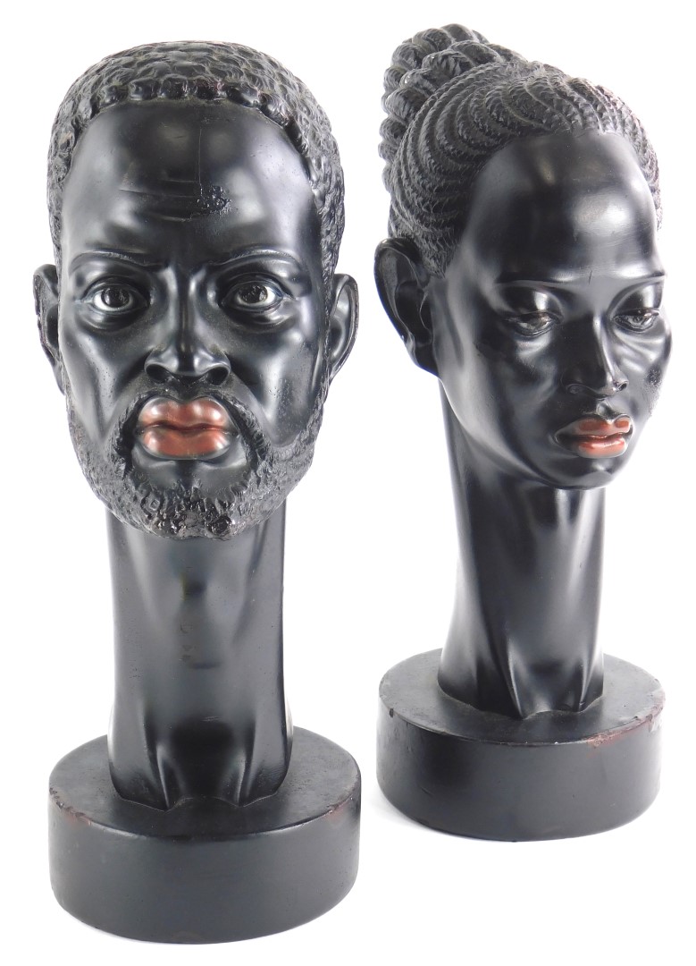 A pair of 1950s/60s ebonised plaster busts, modelled in the form of an African man and lady, each