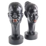 A pair of 1950s/60s ebonised plaster busts, modelled in the form of an African man and lady, each