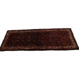 A Persian narrow rug, with an all over design, on a deep navy ground, one wide, two narrow
