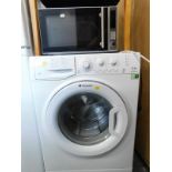 A Hotpoint Aquarius washing machine, WMAQL741, a Silver Crest microwave, and an armchair. The