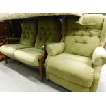 An oak framed two seater green upholstered sofa, and an associated reclining armchair.