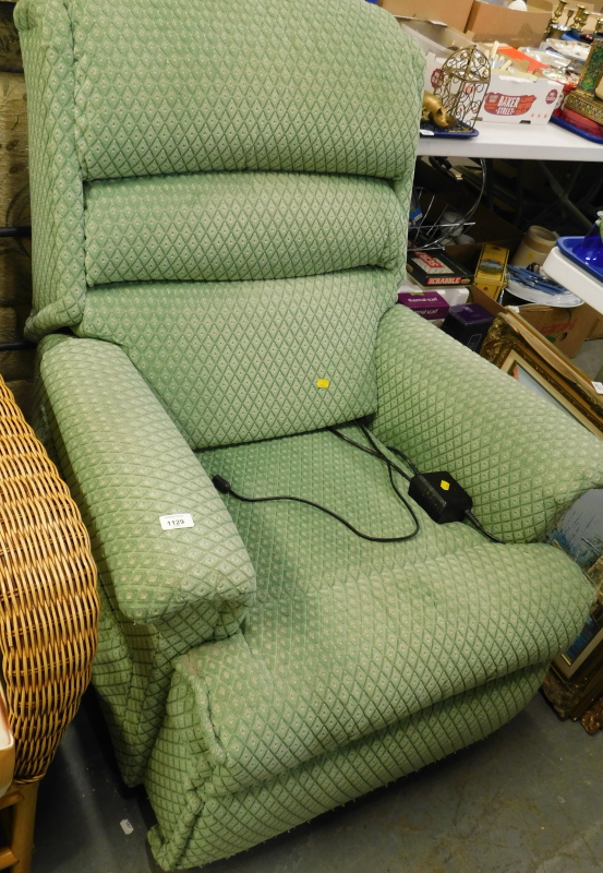 An electric reclining armchair, in green diamond pattern fabric.