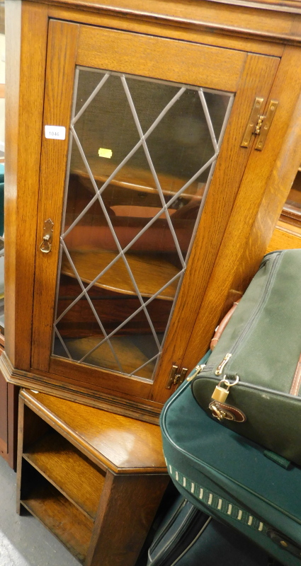 An oak hanging corner cabinet, with a single lead glazed front door, 92cm high, 57cm wide, 20cm