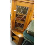 An oak hanging corner cabinet, with a single lead glazed front door, 92cm high, 57cm wide, 20cm