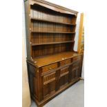 An oak Welsh dresser, the top with pot board, the base with three drawers above three hinged