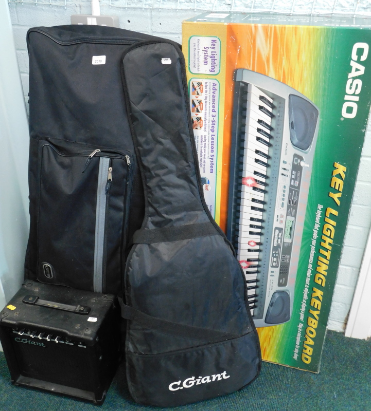 A Casio key lightening keyboard, LK-55, boxed, with outer canvas case, an electric guitar, and a C.