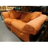 A two seater sofa in orange fabric. The upholstery in this lot does not comply with the 1988 (Fire &