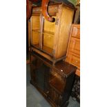 An oak veneered glazed side cabinet, 75cm high, 72cm wide, 27cm deep, together with a wider cabinet,