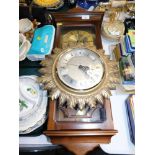 A Metamec clock with numeric dial and pendulum, and a Quartz St James London starburst clock. (2)