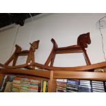 A pair of teak rocking horses.