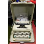An Olympia cased typewriter and various type writer reels.