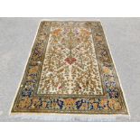 A Keshan machine made rug, beige ground with asymmetrical Venetian urn and floral design pattern, 19